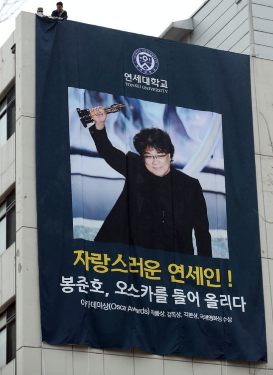 Yonsei University hangs a banner of Bong Joon Ho holding an Oscar Trophy. 
