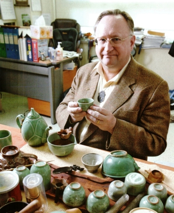 Professor David A. Mason drinking tea in his office. 
